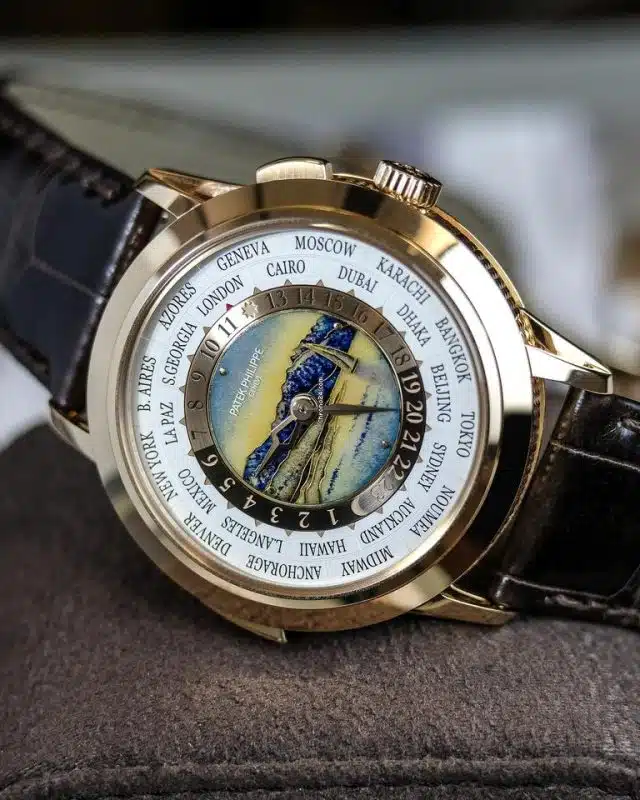Patek Philippe World Time watch in rose gold with cloisonné enamel dial and city ring, featuring a brown leather strap